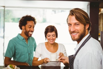 Barista talking with two customers