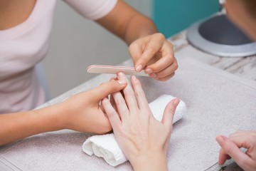 Obraz na płótnie Canvas Nail technician giving manicure to customer