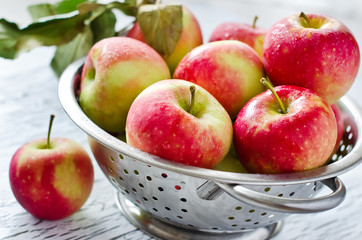 Fresh red apples in a metal colander