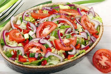 Fresh salad with tomato on wooden background