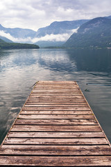Jetty on the misty lake in Alps, Austria