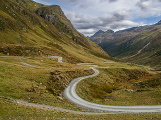 geschwungene Schotterstrasse in den Bergen