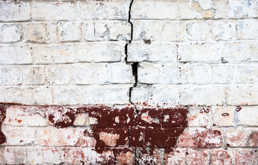 Cracked whitewashed brick wall