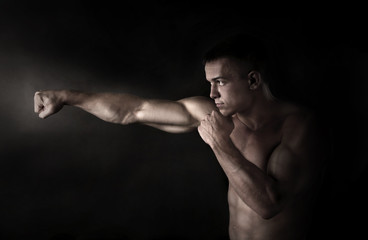 Fototapeta na wymiar Boxer fighter on black background