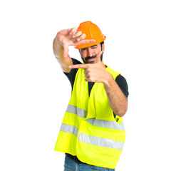 Workman focusing with his fingers on a white background