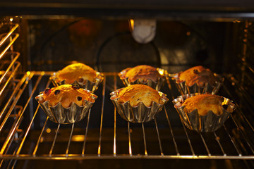 Baking cupcakes with raisins in baskets are baked in the oven
