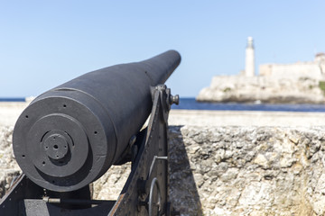 Fototapeta na wymiar Old canon pointing at the lighthouse in Havana, Cuba