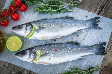Two raw seabass with lime, cherry tomatoes and rosemary