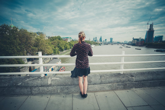 Young woman standing on bridge in city