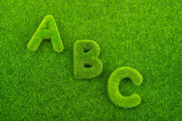 Alphabet letters ABC made from grass with grass background