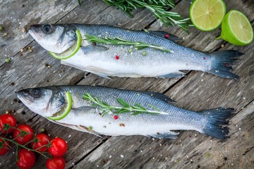 Two raw seabass with lime, cherry tomatoes and rosemary