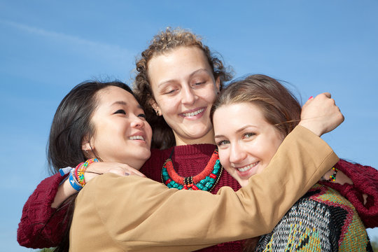 Three young women hugging each other