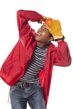scared dark-skinned construction worker holding his helmet