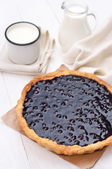 Blueberry pie and milk on white wooden table