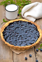 Blueberry pie and milk on rustic wooden table