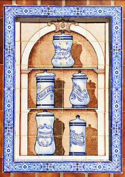 Botes de farmacia, azulejo publicitario en una farnacia. Albarelos cer&aacute;micos