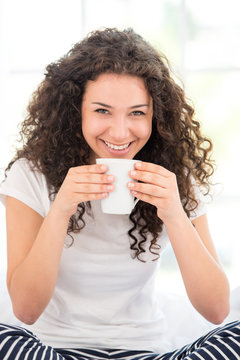 Smiling woman having morning coffee or tea
