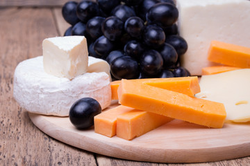 various types of cheese on wooden background