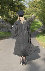 Mature University walking student wearing gown