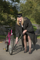 Cap and gown university student pumping tyre