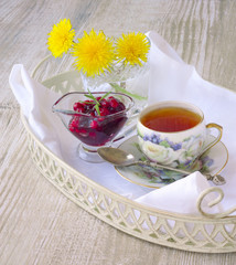 cup of tea with jam on a tray on a white wooden background