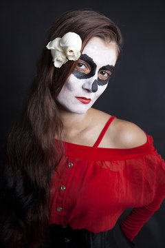 Woman with makeup of la Santa Muerte with white roses