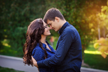 Couple hugging in a park seated in a bench