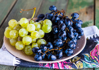 sweet cluster of green and blue grapes on a plate