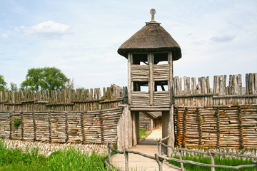Palisade and entrance. The settlement in Biskupin. - obrazy, fototapety, plakaty