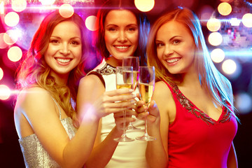 three smiling women with champagne glasses