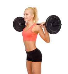 Obraz premium smiling sporty woman exercising with barbell