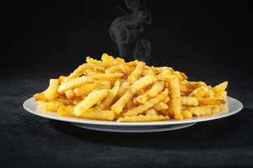 Hot French fries on white plate.