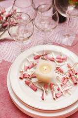 Buffet table with dishware and candle waiting for guests