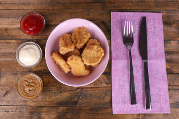 Chicken nuggets with sauces on table close-up