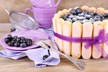 Tasty cake Charlotte with blueberries on wooden table
