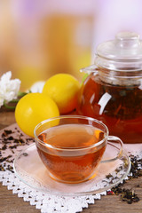 Teapot and cup of tea on table on light background