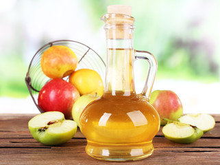 Apple cider vinegar in glass bottle and ripe fresh apples,