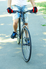 Young man riding bike in city park