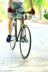 Naklejka premium Young man riding bike in city park