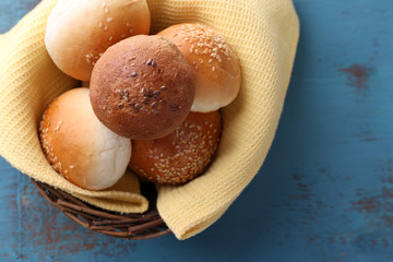 Tasty buns with sesame in wicker basket,