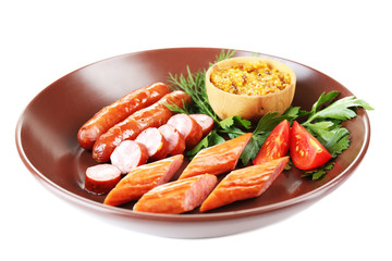 Assortment of tasty thin sausages on plate isolated on white
