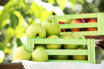 Juicy apples in wooden boxes, outdoors