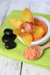 Still life with beautiful blooming orchid flower, towel and sea