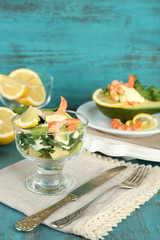 Tasty salads with shrimps and avocado in glass bowl and