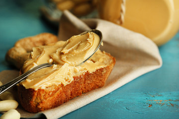 Tasty sandwich with fresh peanut butter on wooden background
