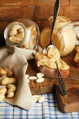 Tasty sandwiches and jar with fresh peanut butter