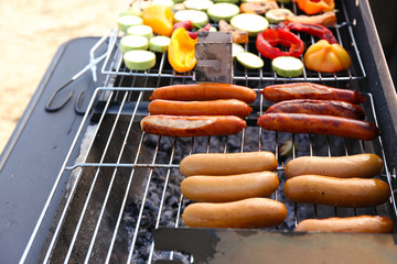 Sausages and vegetables on barbecue grill, close-up