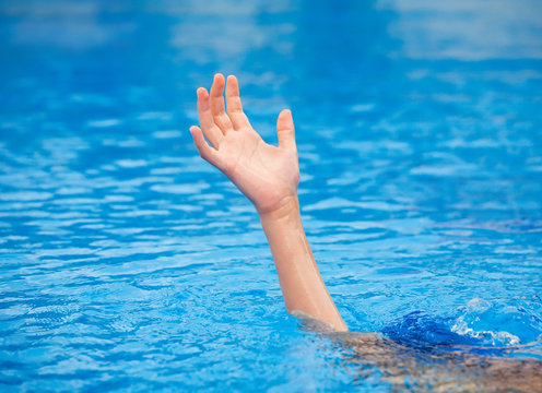 A hand of a drowning person stretching out of the water 