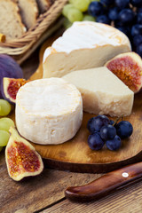 Cheese plate. Variety of cheese sorts with grapes and figs