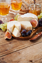 Cheese plate. Variety of cheese sorts with grapes and figs